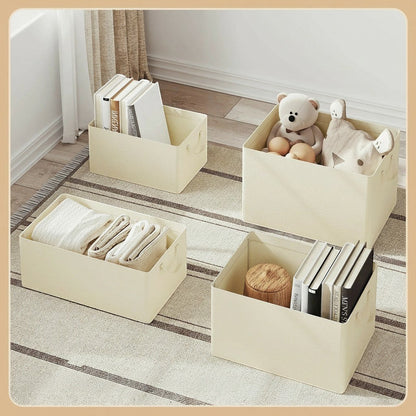 Tokari set van vier beige opbergboxen met handvatten voor kleding, boeken en speelgoed op een gestreept tapijt.
