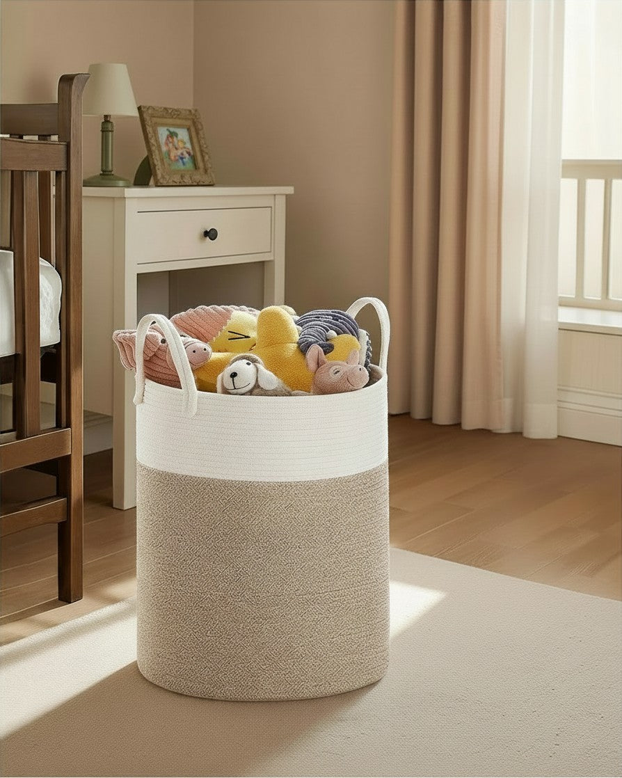 Tokari katoenen wasmand van 60 liter in beige en wit met stevige handgrepen, gevuld met knuffels in een slaapkamer.