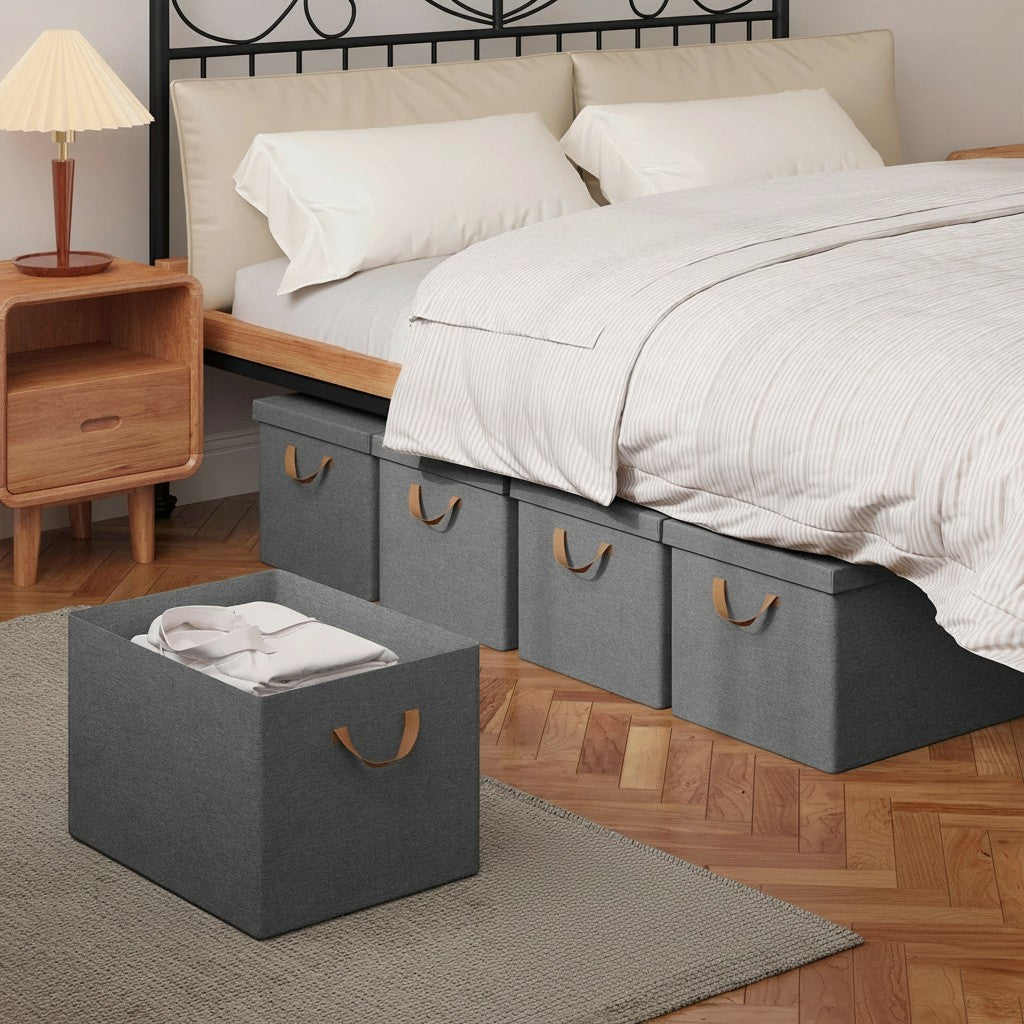Tokari opvouwbare grijze opbergboxen met deksel en bruine handvatten, geplaatst onder een bed in een slaapkamer.