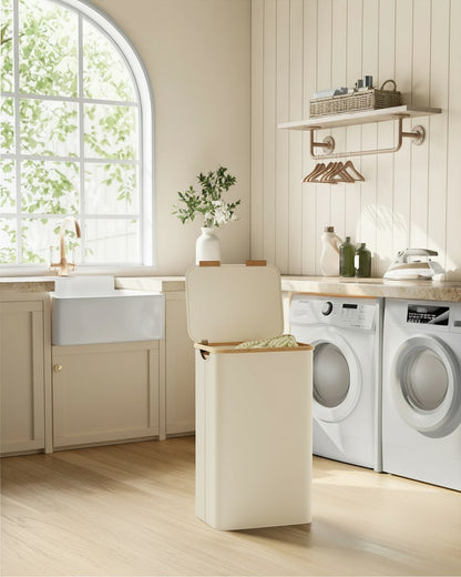 Tokari opvouwbare wasmand van 90 liter in beige Oxfordstof met deksel, geplaatst in een lichte wasruimte.