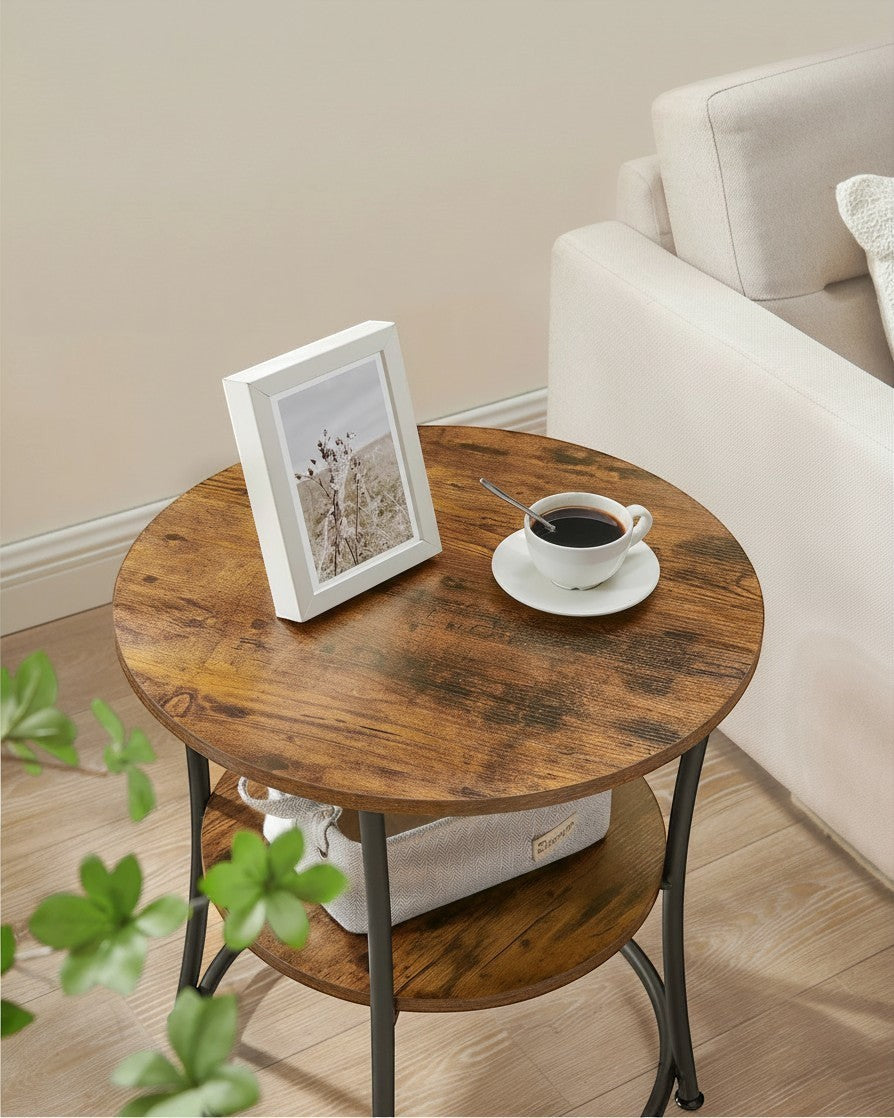 Tokari ronde bijzettafel met twee niveaus in rustiek bruin hout en zwart staal naast een beige bank.