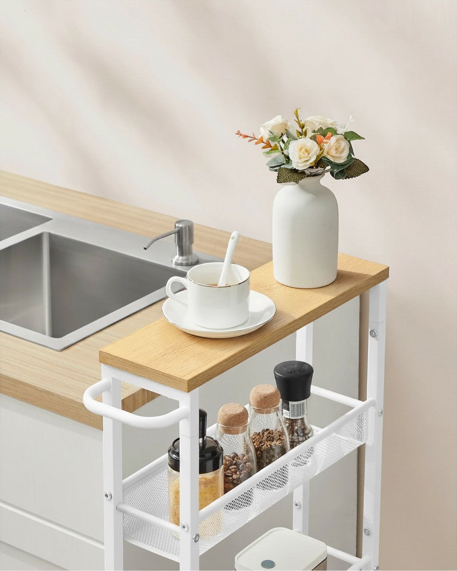 Tokari smalle keukentrolley met 5 niveaus in eiken en wit staal, geplaatst naast een aanrecht in een lichte keuken.