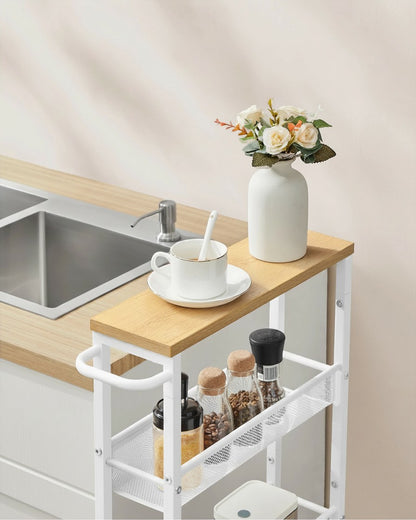 Tokari smalle keukentrolley met 5 niveaus in eiken en wit staal, geplaatst naast een aanrecht in een lichte keuken.