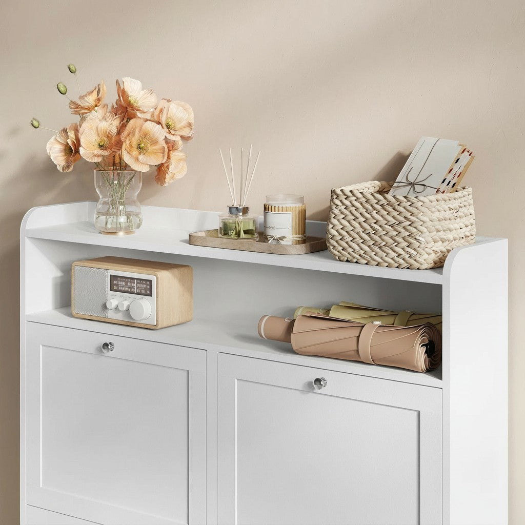 Tokari smalle witte schoenenkast met open opbergplank, decoratieve bloemen en accessoires in een moderne hal.