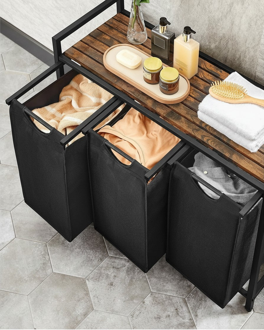 Tokari wassorteerder met drie zwarte stoffen zakken en een houten legplank voor badkamer of wasruimte